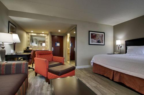 a hotel room with a bed and a chair and a desk at Hampton Inn & Suites Spartanburg-I-26-Westgate Mall in Spartanburg