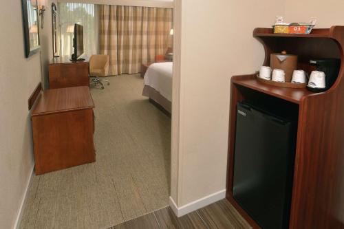 a hotel room with a bedroom with a bed and a mirror at Hampton Inn Springfield-South in Springfield