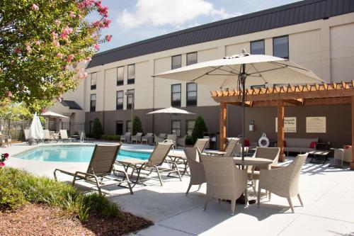 a patio with a table and chairs and an umbrella at Hampton Inn Tuscaloosa-University in Tuscaloosa