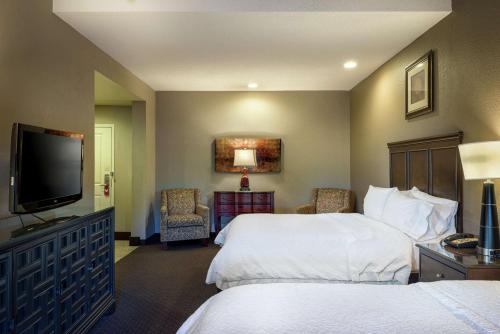 a hotel room with two beds and a flat screen tv at Hampton Inn Tuscaloosa-University in Tuscaloosa