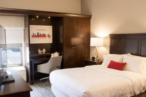 a hotel room with a bed and a desk and a computer at Hampton Inn Tuscaloosa-University in Tuscaloosa