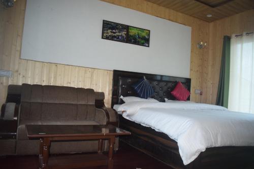 a bedroom with a bed and a couch at Himrab Chopta Resort in Chopta
