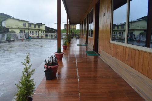 a flooded porch of a building with potted plants at Himrab Chopta Resort in Chopta