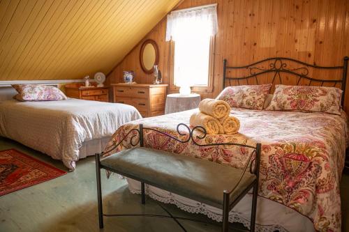 a bedroom with two beds and a teddy bear on a chair at Bed & café Petit Papillon in Grandes-Bergeronnes