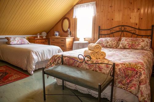 1 dormitorio con 2 camas y un osito de peluche en una silla en Bed & café Petit Papillon, en Grandes-Bergeronnes