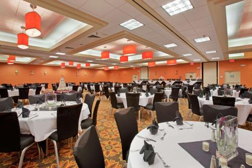 a banquet hall with white tables and black chairs at DoubleTree by Hilton Springfield in Springfield