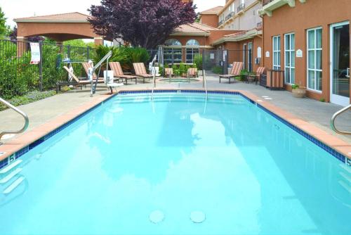 a large blue swimming pool in front of a building at Hilton Garden Inn Napa in Napa
