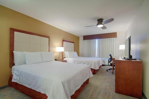 a hotel room with two beds and a flat screen tv at Homewood Suites by Hilton Las Vegas Airport in Las Vegas
