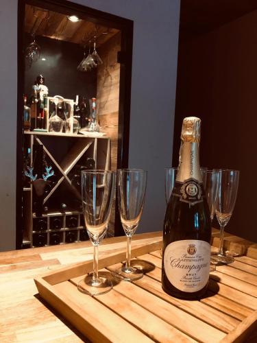a bottle of champagne sitting on a table with wine glasses at The Hideaway in Les Gets