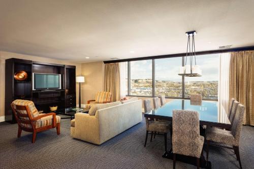 a living room with a dining table and a living room with a view at Doubletree By Hilton Billings in Billings