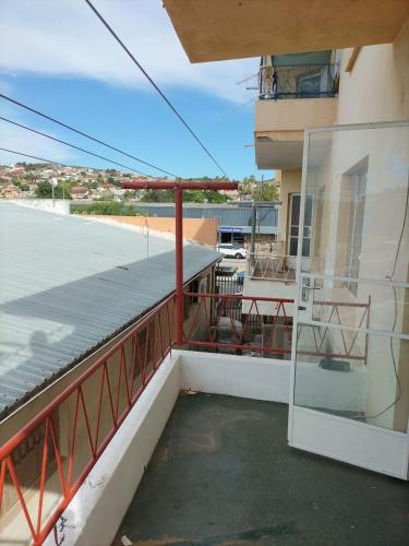 a balcony with a red railing and a building at Despatch Self Catering Apartments in Despatch