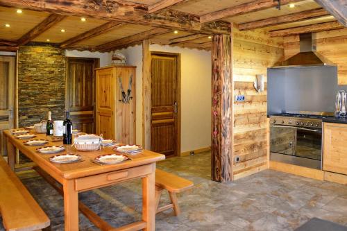 a kitchen with a wooden table in a room at L'Ecrin des Granges-Le Roc in Villarembert