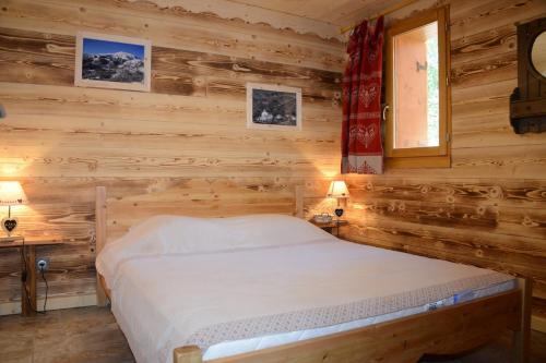 a bedroom with a bed in a log cabin at L'Ecrin des Granges-Le Roc in Villarembert