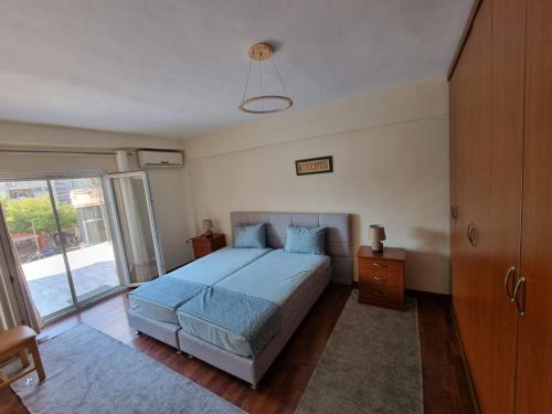a bedroom with a bed and a large window at Solaris Guest House in Shkodër