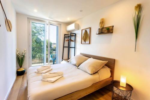 un grand lit dans une chambre avec une grande fenêtre dans l'établissement L'élégant / Sauna / 24h/24h, à Saint-Jory