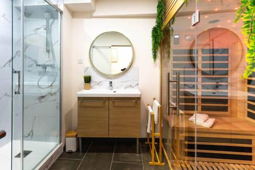 une salle de bain avec un lavabo, une douche et un miroir dans l'établissement L'élégant / Sauna / 24h/24h, à Saint-Jory