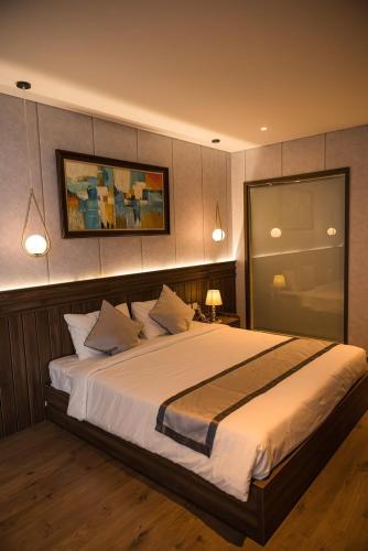 um quarto com uma cama grande com lençóis brancos e almofadas em Khách sạn 5* Apec Mandala Mũi Né - 1G 1m8 em Ấp Thiẹn Ái