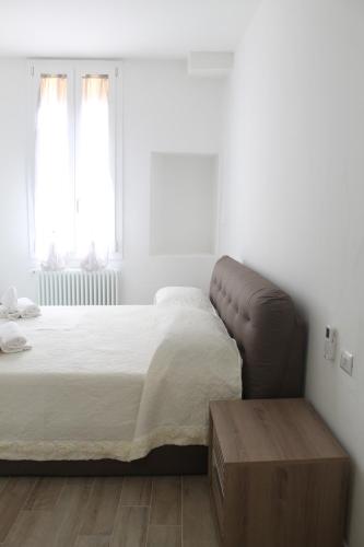 a bedroom with a large bed and a wooden table at Appartamento San Vitale in Bologna