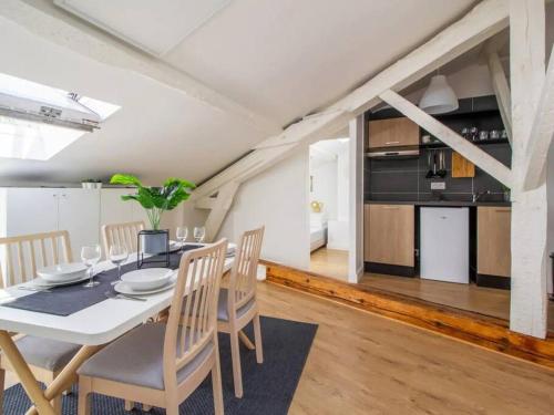 une salle à manger avec une table et des chaises et une cuisine dans l'établissement Le Nid Douillet • Proche Métro • Quartier St-Aubin, à Toulouse