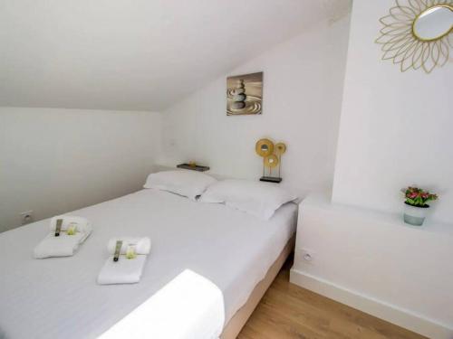 - une chambre blanche avec 2 lits et un miroir dans l'établissement Le Nid Douillet • Proche Métro • Quartier St-Aubin, à Toulouse