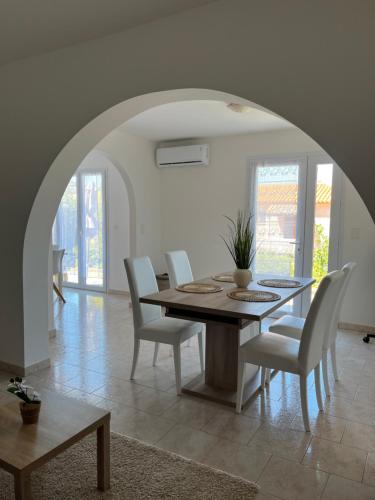 une salle à manger avec une table et des chaises blanches dans l'établissement Appartement rez de villa, à LʼÎle-Rousse