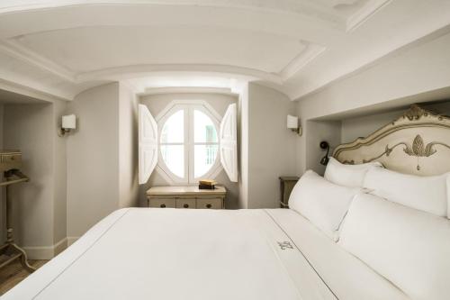 a bedroom with a large white bed and a window at Domus Zamittello in Valletta