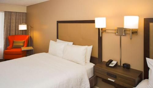 ein Hotelzimmer mit einem Bett und einem Telefon auf dem Tisch in der Unterkunft Hampton Inn & Suites Valdosta/Conference Center in Valdosta