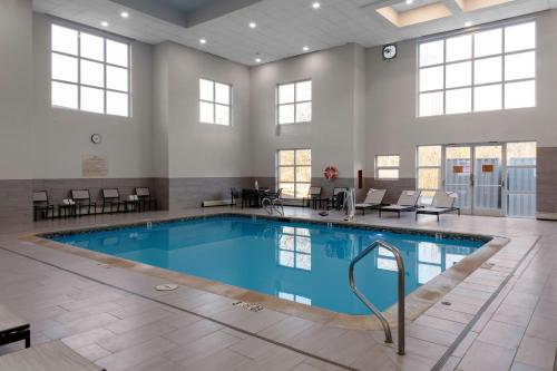 a swimming pool in a large room with windows at Hampton Inn by Hilton Concord/Bow in Concord