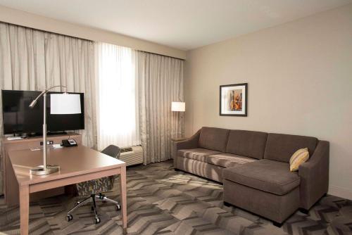 a living room with a couch and a desk in a hotel room at Hampton Inn & Suites by Hilton Thunder Bay in Thunder Bay