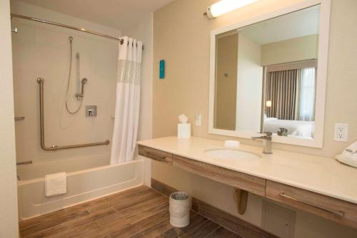 ein Bad mit einem Waschbecken, einer Dusche und einem Spiegel in der Unterkunft Hampton Inn & Suites by Hilton Thunder Bay in Thunder Bay