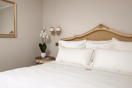 a white bed with white pillows and a mirror at Domus Zamittello in Valletta