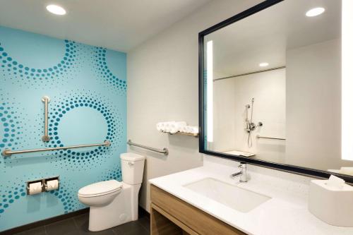 y baño con aseo, lavabo y espejo. en Tru By Hilton York Pa en York
