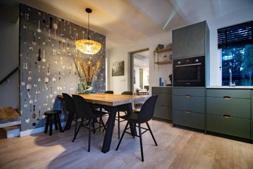 uma cozinha com uma mesa de jantar e cadeiras em B&B de oude melkfabriek em Valkenswaard