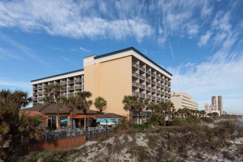 a hotel on the beach with palm trees at Hampton Inn Oceanfront Jacksonville Beach in Jacksonville Beach