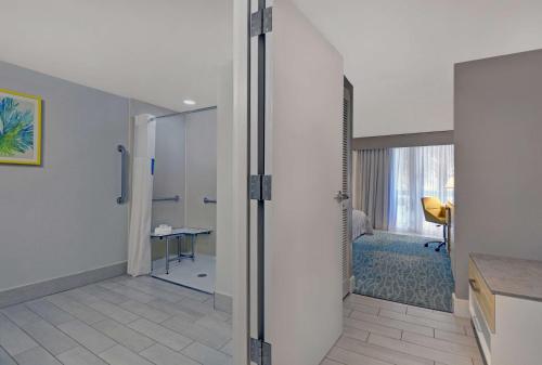 a bathroom with a walk in shower and a room at Hampton Inn Oceanfront Jacksonville Beach in Jacksonville Beach