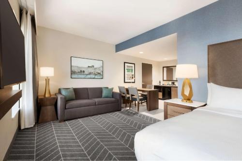 a hotel room with a bed and a couch at Embassy Suites By Hilton Wilmington Riverfront in Wilmington