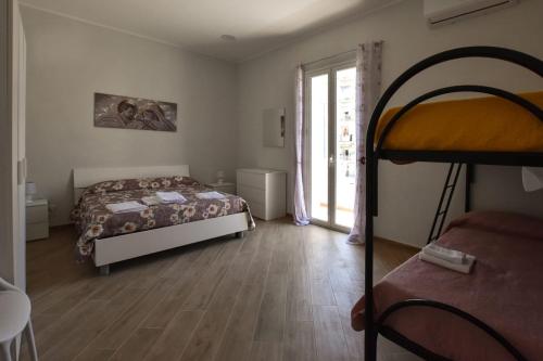 a bedroom with a bed and a large window at essegiHome in Porto Empedocle