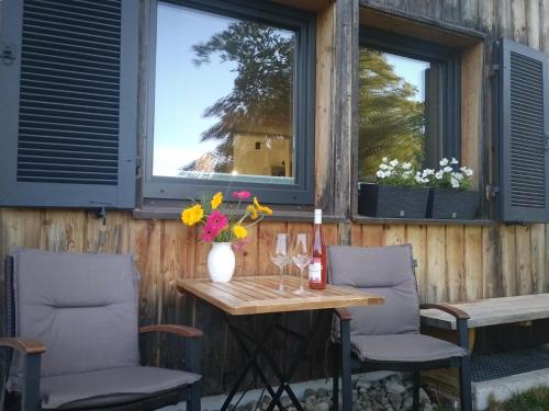 a table with two chairs and a vase of flowers at Ferienwohnung Werner in Inzell