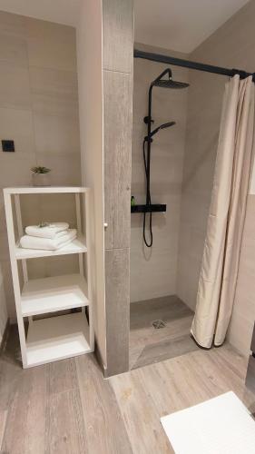 a bathroom with a shower and a shelf with towels at Ferienwohnung Werner in Inzell
