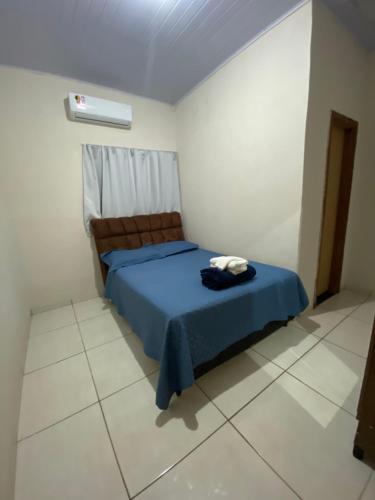 a bedroom with a blue bed in a white room at Recanto Sonho - PX Palmas Brasil in Palmas