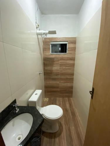 a small bathroom with a toilet and a sink at Recanto Sonho - PX Palmas Brasil in Palmas