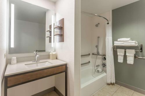 a white bathroom with a sink and a shower at Hilton Garden Inn Chicago/Tinley Park in Tinley Park