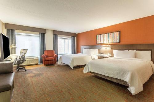 a hotel room with two beds and a television at Hilton Garden Inn Chicago/Tinley Park in Tinley Park