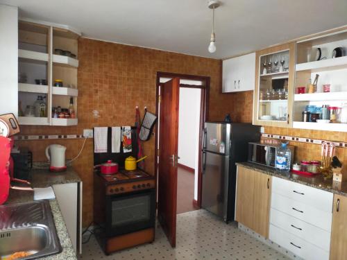 a kitchen with a stove and a refrigerator at Beautiful spacious room in Nairobi
