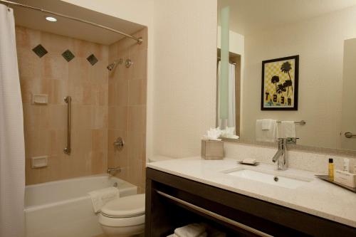 a bathroom with a sink and a toilet and a tub at Hilton Palm Springs in Palm Springs