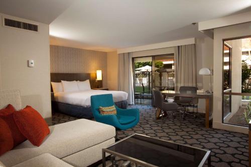 a hotel room with a bed and a couch at Hilton Palm Springs in Palm Springs