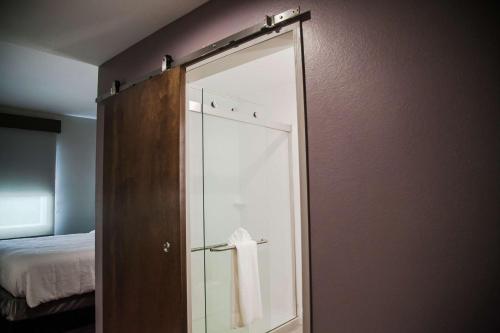uma casa de banho com uma porta de vidro e uma toalha em Hilton Garden Inn Tampa Suncoast Parkway em Lutz