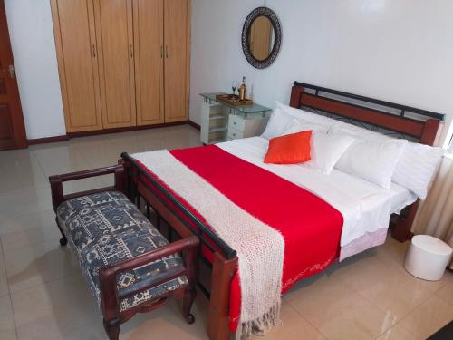 a bedroom with a bed with a red and white blanket at Beautiful spacious room in Nairobi