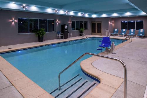 a large pool in a hotel room with blue chairs at Hampton Inn & Suites Atlanta/Marietta in Marietta