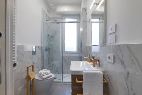 a white bathroom with a shower and a sink at Contempora Apartments - bilocale Washington 105 in Milan
